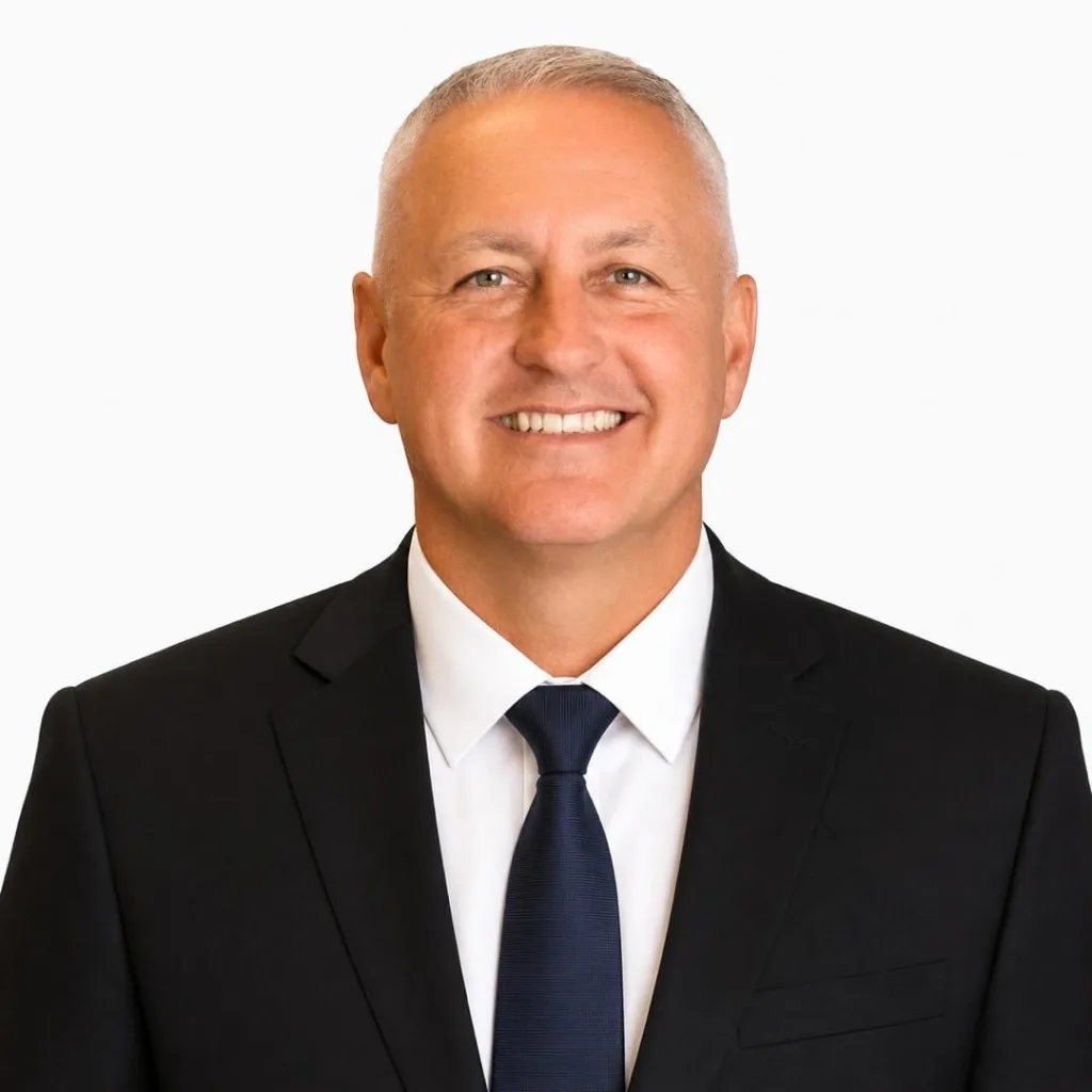 Jim Otto Wagner, CEO of Jimfield Engineering, wearing a black suit and navy tie, smiling against a white background.